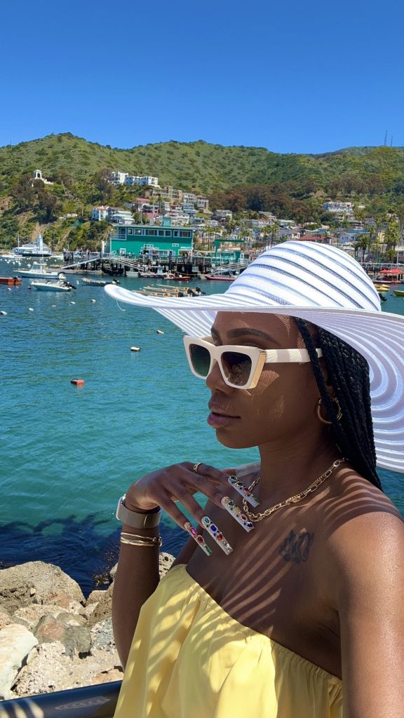 Sucoyia wearing a sun hat and sunglasses near the waterfront on Catalina Island.